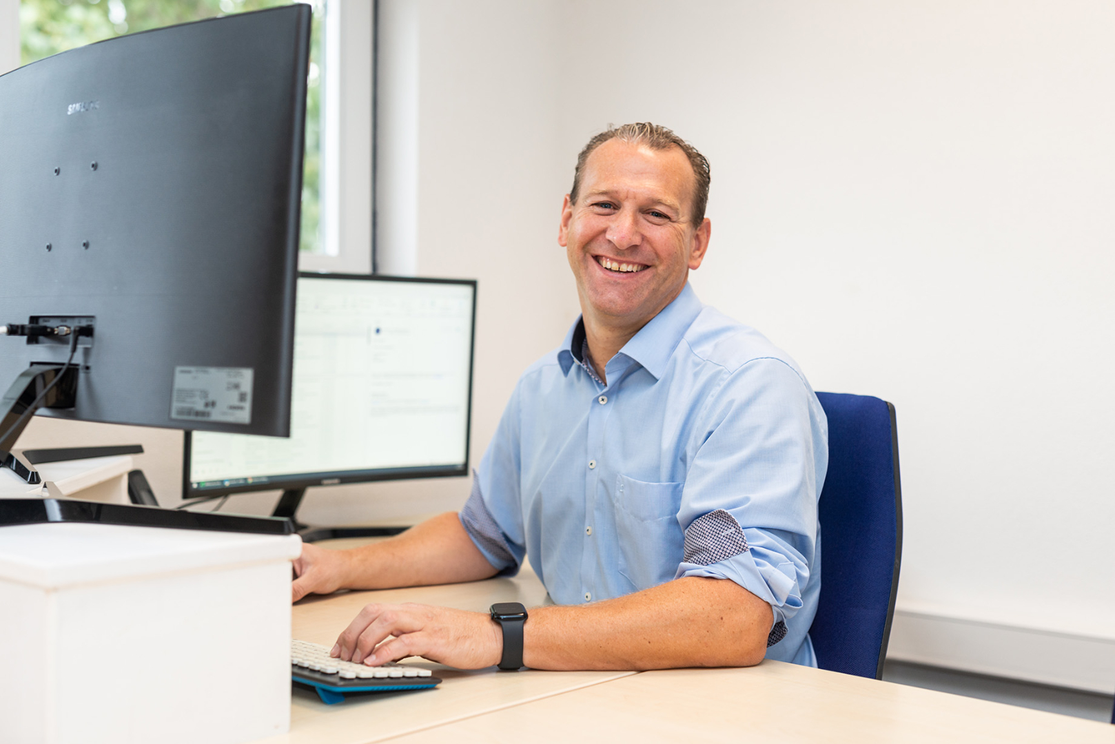 Lachende man aan bureau